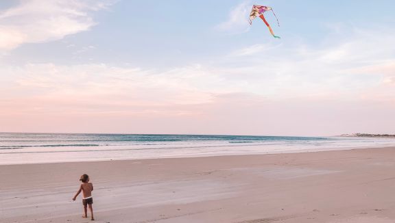 Kid flying a kite on the beach at Walker's Rock (Carly Kruger)